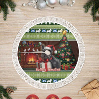 Round Christmas tree skirt with fringed white trim and terrier by fireplace, green design.