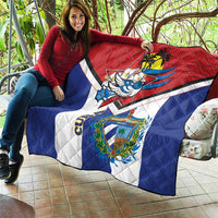 Cuba-themed quilt draped on couch, red top, blue sides, white center, bird and crest