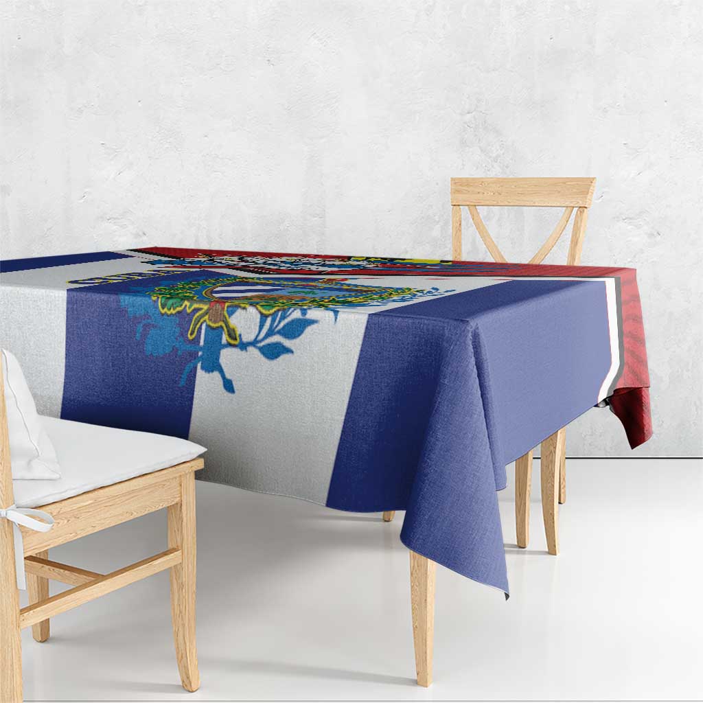Cuban-themed tablecloth with blue panel and multicolor border, overhanging table edge