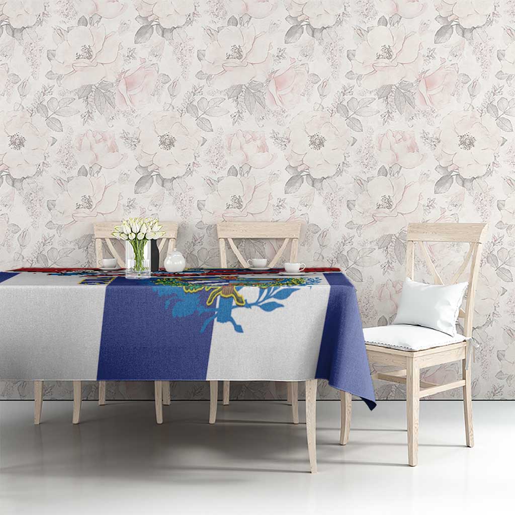 Cuban-themed tablecloth on dining table, blue and white with colorful emblem, chair view