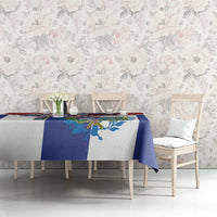 Cuban-themed tablecloth on dining table, blue and white with colorful emblem, chair view
