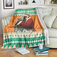 Christmas blanket with green and orange elephants and Santa, draped over sofa back