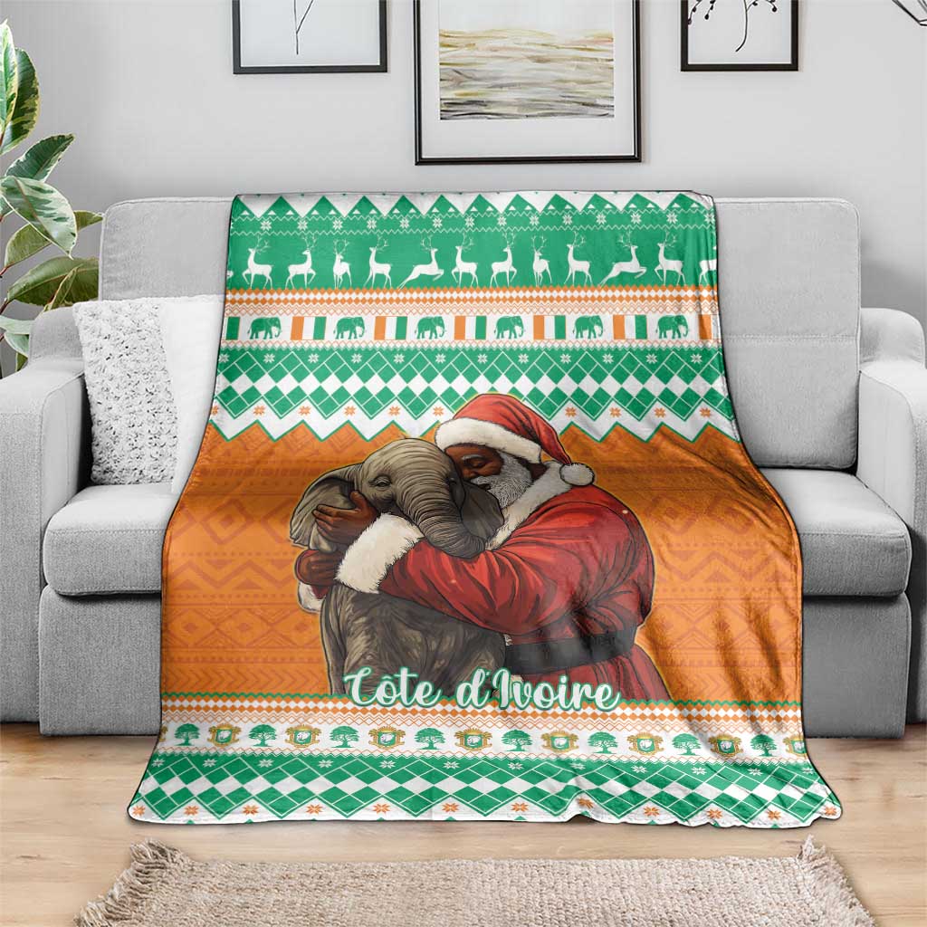 Christmas blanket with green and orange elephants and Santa design, spread on couch