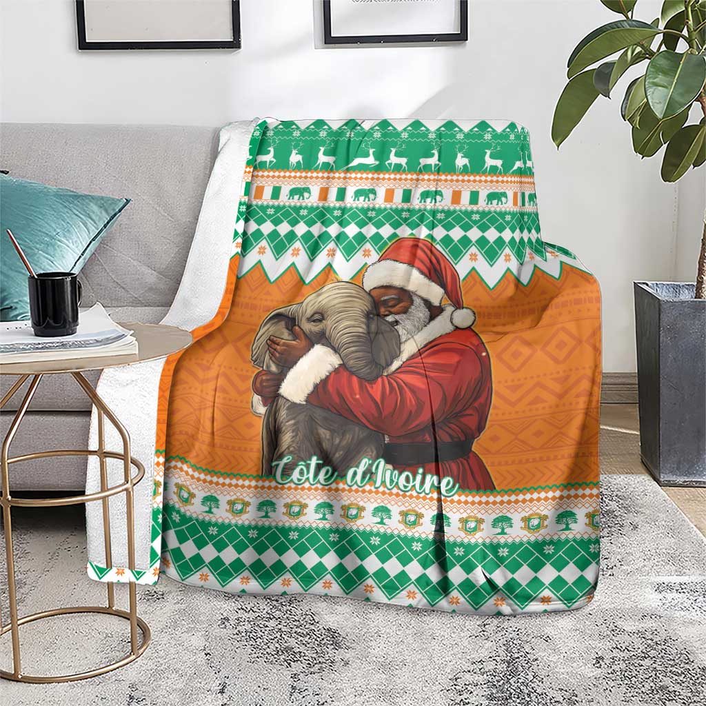 Christmas blanket with green and orange elephants and Santa, draped on gray chair