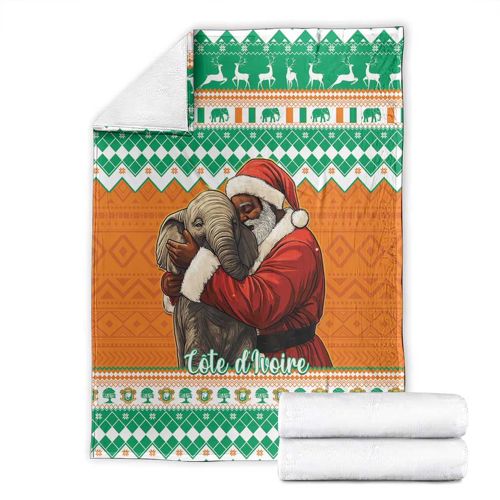 Christmas blanket with green and orange elephants and Santa, folded with white towels