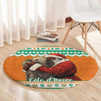 Round orange Christmas carpet with elephant hugging Santa design, green border, on light wood floor