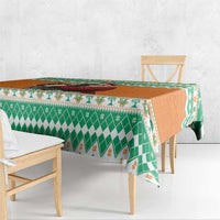Festive tablecloth with green and orange holiday pattern on a table edge