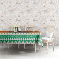 Holiday tablecloth with green geometric band and orange accents on dining table