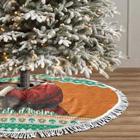 Round Christmas tree skirt with white tassel fringe and green-orange elephant Santa motif