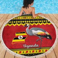 Round Uganda beach blanket laid flat with crowned crane and Uganda map flag print, fringed edge