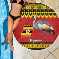 Round Uganda beach blanket draped over a woman in a black swimsuit, crowned crane and flag map print
