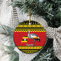 Christmas ceramic round ornament on tree branches, red Uganda design with grey crowned crane.