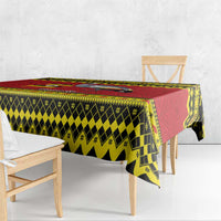 Uganda Christmas tablecloth draped on table edge, red yellow black patterned fabric