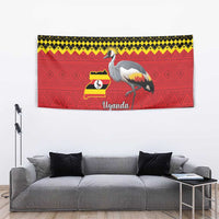 Red wall tapestry featuring crowned crane, Uganda flag map badge, and yellow-black patterned border