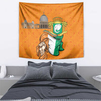 Orange wall tapestry showing green flag figure, coat of arms badge, and city buildings