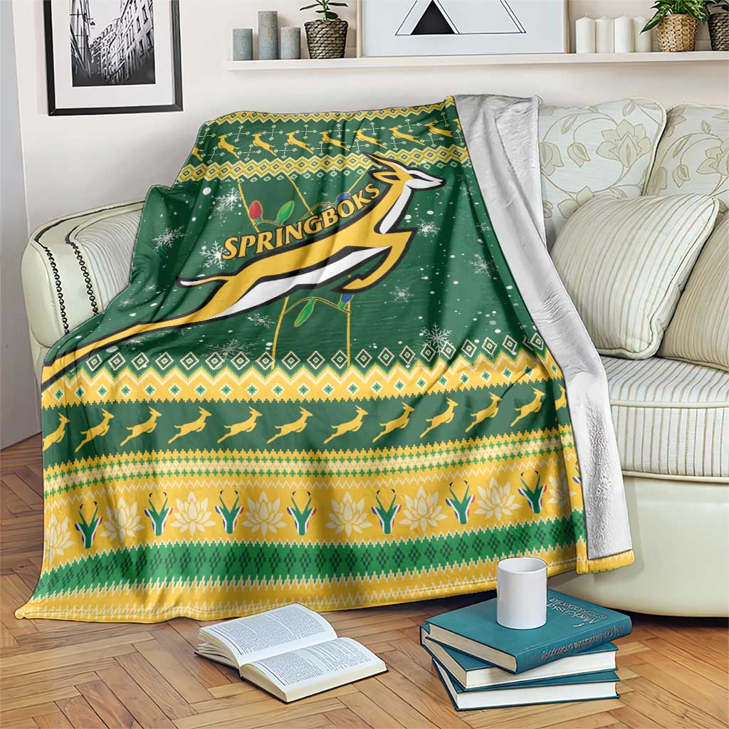 Green and yellow Springbok rugby Christmas blanket draped over couch with bold logo