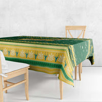Green and yellow patterned Christmas tablecloth draped over table