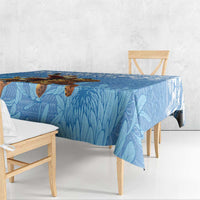 Blue Christmas tablecloth with Santa-and-leopard print and flowing leaf pattern along the edge