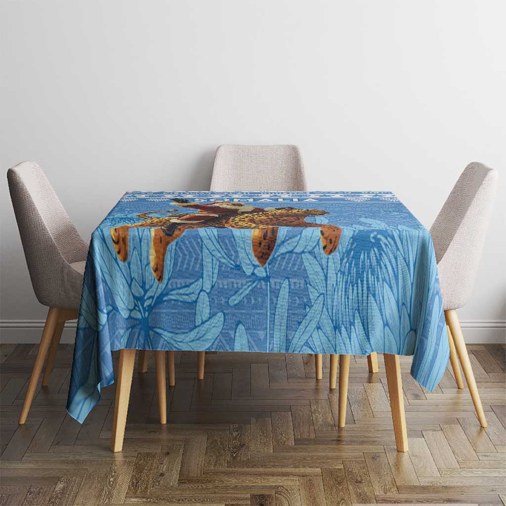 Blue Christmas tablecloth on dining table, Santa and leopard motif centered on leaf pattern