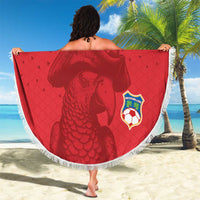 Red round beach blanket with tassel fringe, pirate graphic and Seychelles soccer badge.