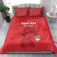 Red pirate-themed bedding set on bed with two pillows, parrot artwork and shield crest