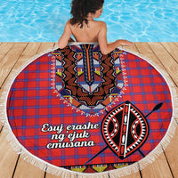 Round beach blanket with red and blue plaid center design and white tassel fringe edge