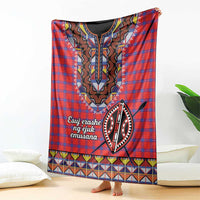 Red plaid shuka blanket with central black-and-white motif and colorful geometric border