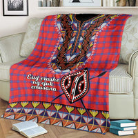 Red plaid shuka throw blanket with black-and-white embroidered face motif and patterned hem