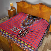 Masai shuka quilt on bed: red-blue plaid center dashiki panel with geometric border strip