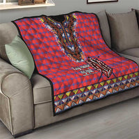 Masai shuka quilt on sofa: red-blue plaid top with black dashiki panel and geometric edge