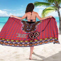 Red plaid sarong with large central beadwork motif, black trim, and striped bottom border