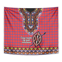 Close-up of red and blue plaid shuka tapestry with beadwork face, shield, and white script