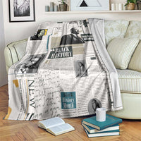 White newspaper-style blanket with Black History collage portraits, draped over furniture