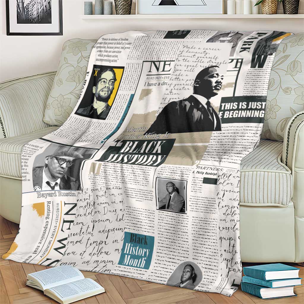 White newspaper-style blanket with Black History collage draped across couch cushions