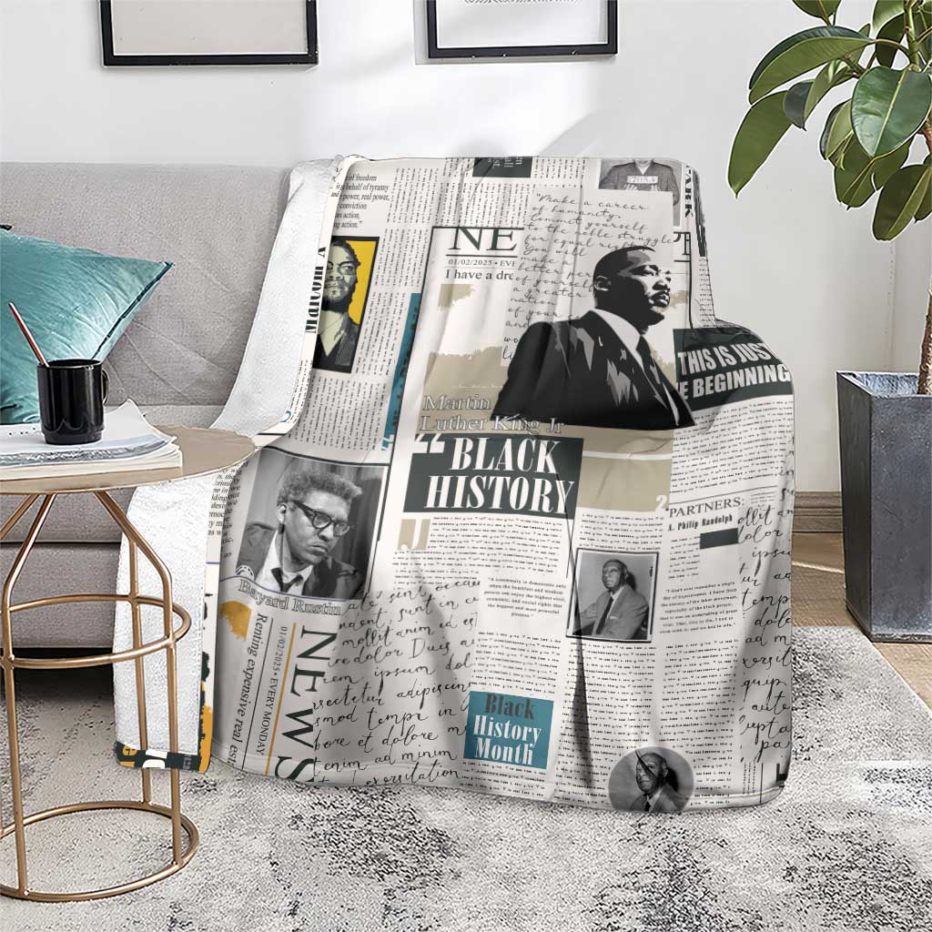 White newspaper-style blanket with Black History collage spread on a gray sofa
