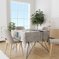 Newspaper print tablecloth draped over dining table with black-and-white typography design
