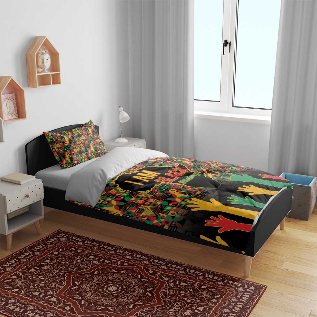 I AM Black bedding set on bed with gray base and colorful map-and-hands artwork.