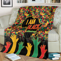 Black History Month blanket on couch, “I AM BLACK” graphic with patterned background and hands