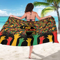 Colorful sarong worn from behind, 'I AM BLACK' text and raised hand silhouettes