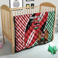 Kenya flag style quilt blanket on a crib with red, white, green stripes and crest