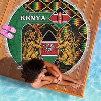 Round green Kenya beach blanket with kente pattern border, shield, lions, white fringe