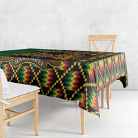 Green kente-pattern tablecloth with coat of arms medallion, draped over table