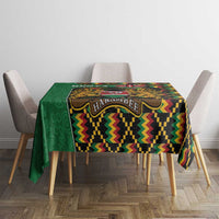 Green kente-pattern tablecloth on rectangular table with coat of arms emblem center