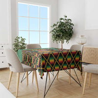 Green kente-pattern tablecloth covering dining table with colorful zigzag design
