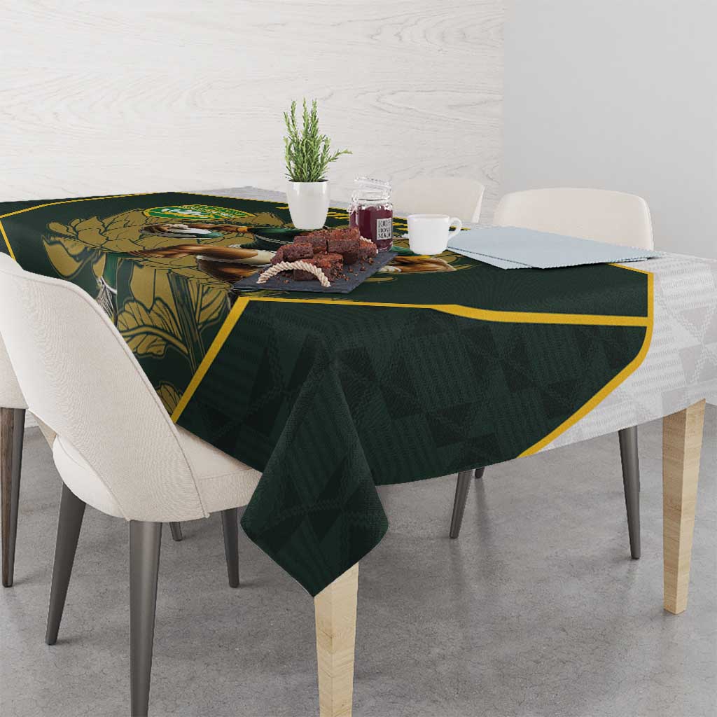 Green tablecloth with yellow-trim border and rugby mascot print on table