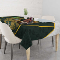Green tablecloth with yellow-trim border and rugby mascot print on table