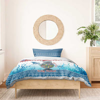 Blue Christmas bedding set on bed with manatee center print and 'Feliz Natal' stripe