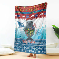 Blue and red Christmas blanket featuring a manatee with festive lights and “Feliz Natal”