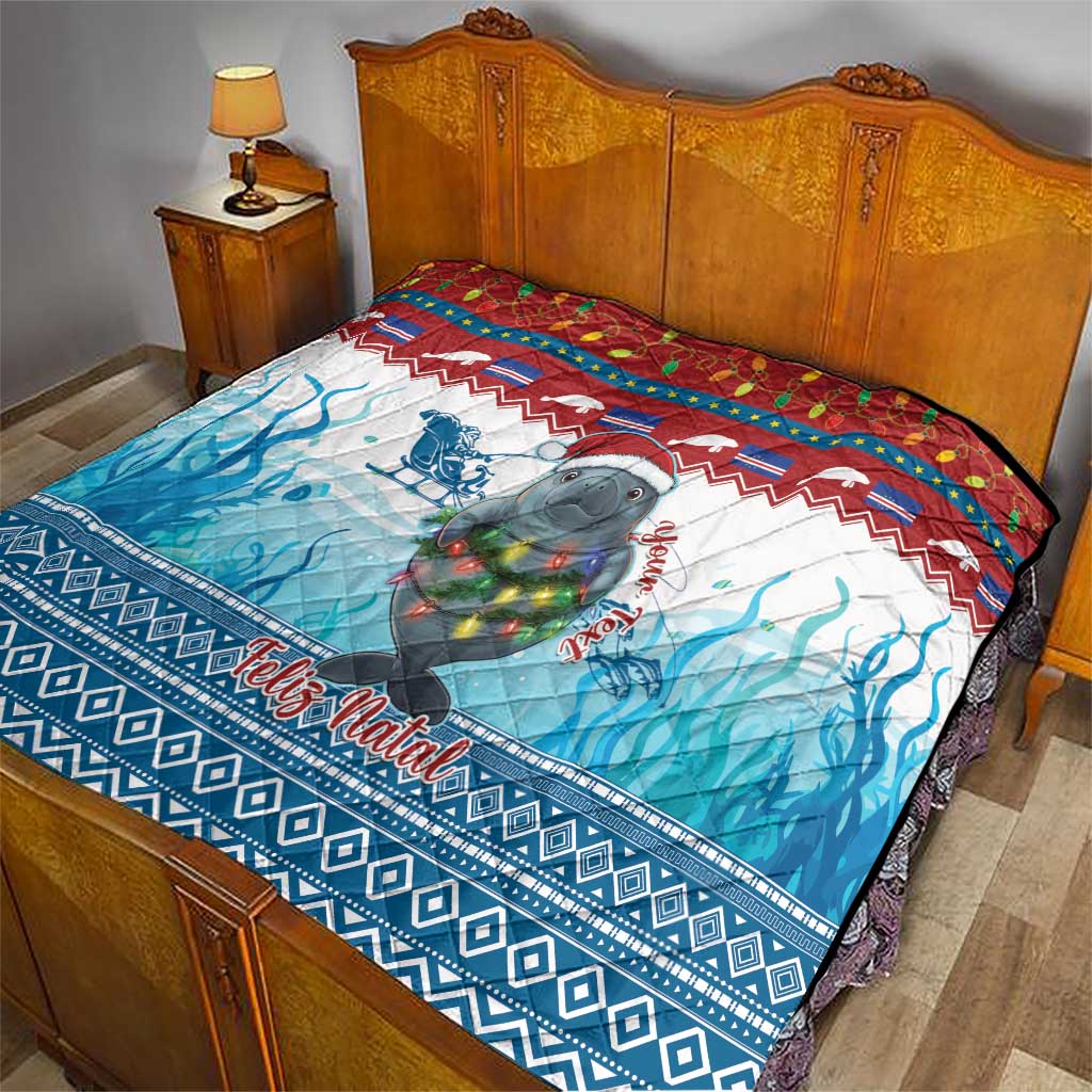 Blue Christmas quilt with manatee and Feliz Natal, laid over a bed with blue wave design