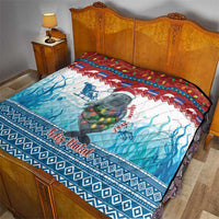 Blue Christmas quilt with manatee and Feliz Natal, laid over a bed with blue wave design